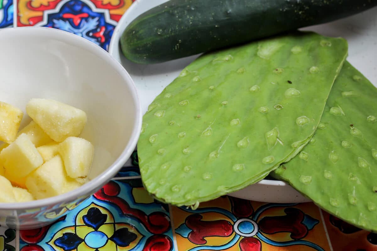 ingredients for a nopal smoothie including nopales, cucumber, and frozen pineapple