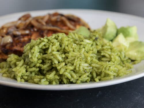 Plate with mexican green rice and chicken breast.